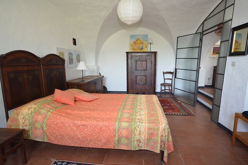 Schlafzimmer mit Doppelbett im Souterrain ,  Moskitonetz