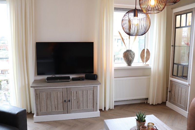 Elegantes Wohnzimmer mit Holzmöbeln, Fernseher und Chandelier.