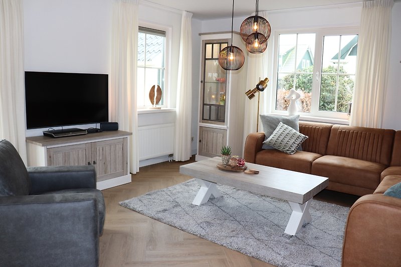 Stilvolles Wohnzimmer mit bequemer Couch, Fenster und Lampe.