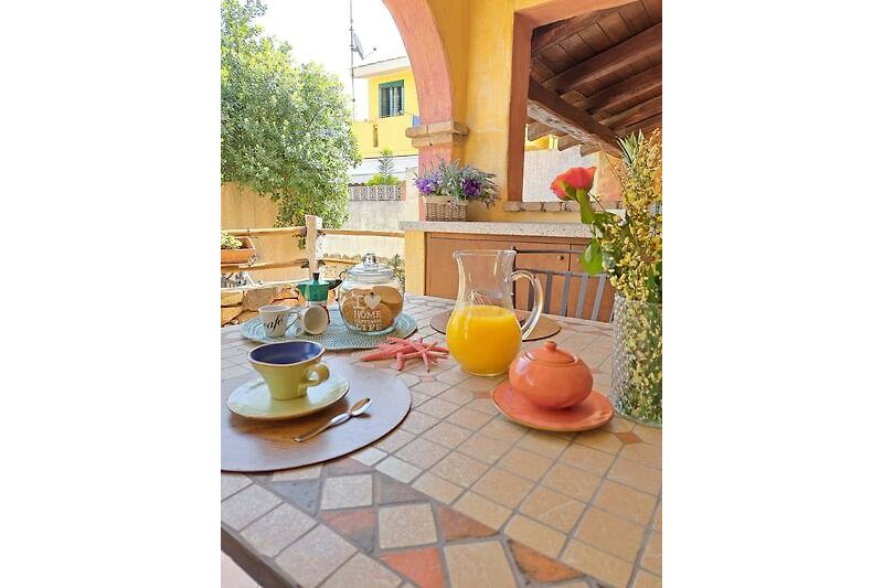 Gemütliche Terrasse mit Tisch, Stühlen und Pflanzen. Gemütliche Atmosphäre.