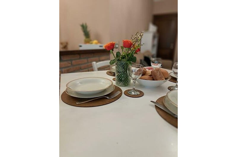 Elegante Tischdekoration mit Blumen und Porzellan.
