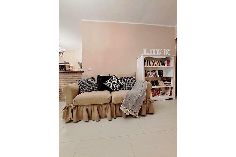 Bequemer Sessel mit Kissen und Lampe in einem stilvollen Raum.