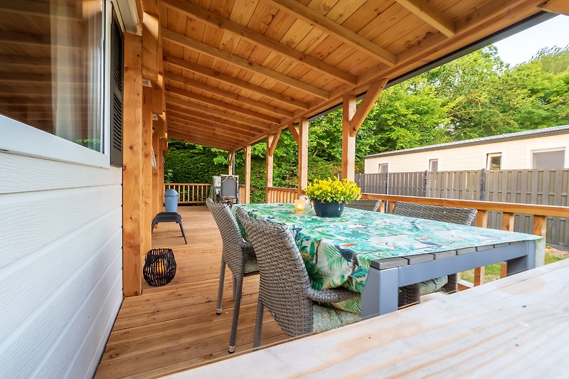 Rustikale Veranda mit Holztisch, Stühlen und Pflanzen. Gemütliche Atmosphäre.