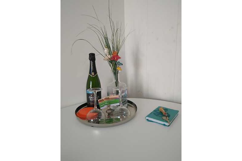 Elegante Tischdekoration mit Blumen, Glaswaren und Flaschen.