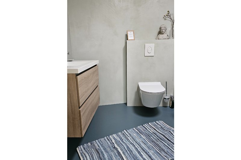 Badezimmer mit modernem Waschbecken und Toilette.