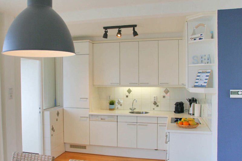 Moderne Küche mit Holzschränken, Spüle und Beleuchtung.