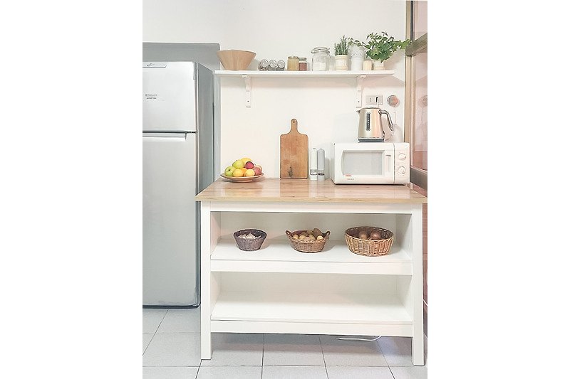 Küche mit Holzregal, Geschirr und Metallflasche.