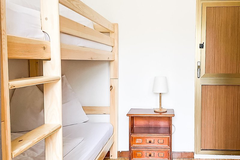 Schönes Schlafzimmer mit Holzmöbeln und gemütlichem Bett.