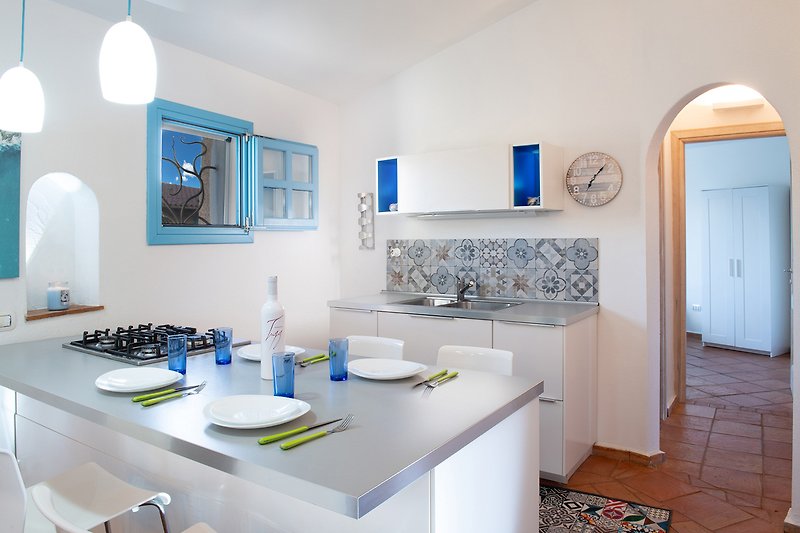 Moderne Küche mit blauen Schränken und Spiegel.