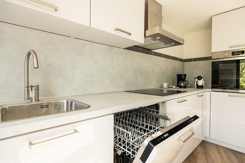 Moderne Küche mit Edelstahl-Spüle und stilvollem Design.