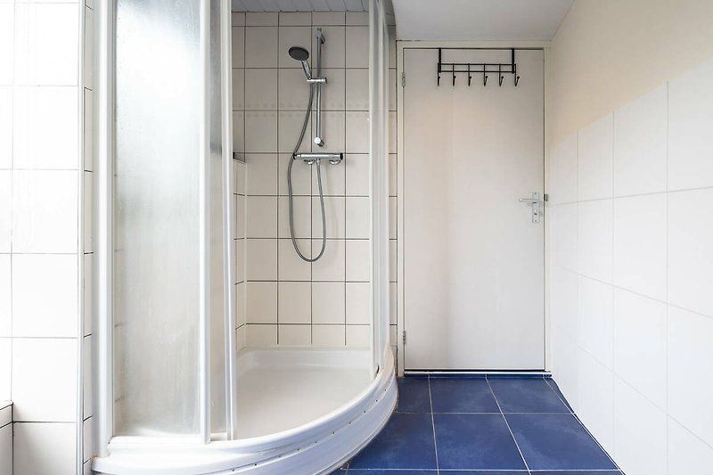Modernes Badezimmer mit Glasdusche, Badewanne und Armaturen.