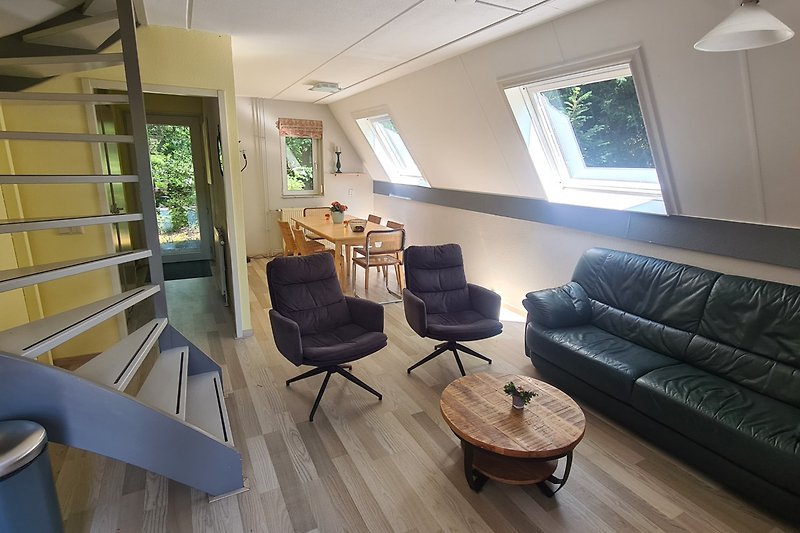 Wohnzimmer mit Holzmöbeln, bequemer Couch und Pflanze.