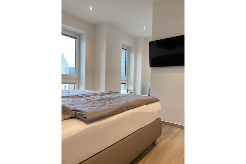 Modernes Schlafzimmer mit Boxspringbett und TV