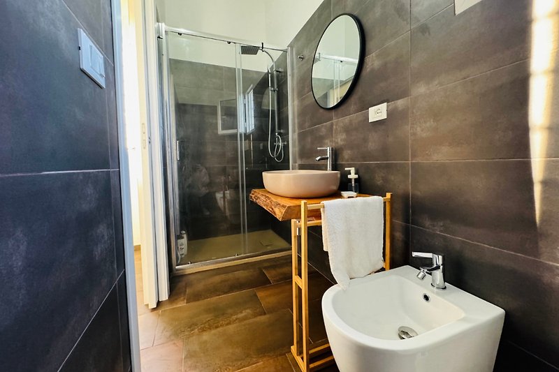 Modernes Badezimmer mit lila Waschbecken und Spiegel.