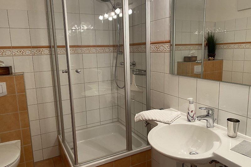 Modernes Badezimmer mit Glasdusche und Armaturen.