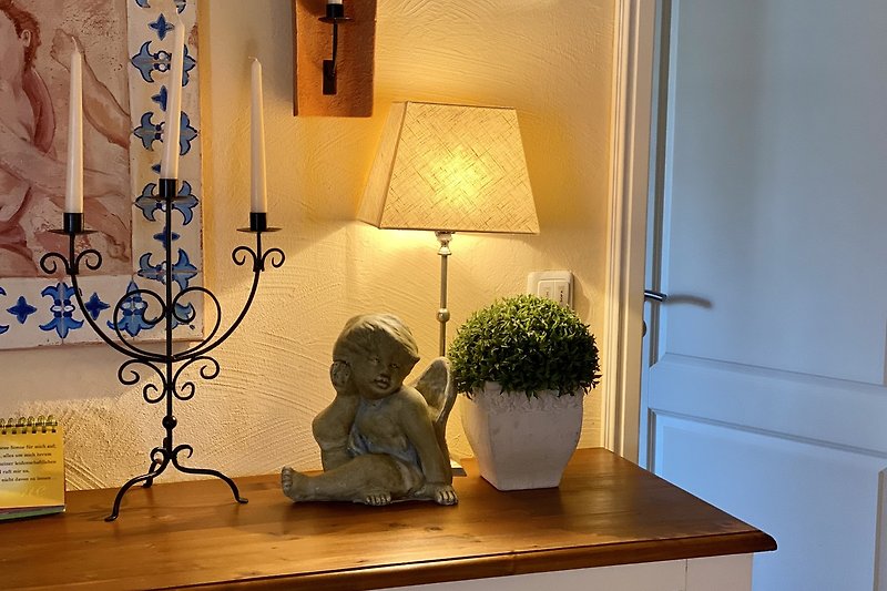 Kunstvolles Wohnzimmer mit Pflanzen, Lampen und Bilderrahmen.
