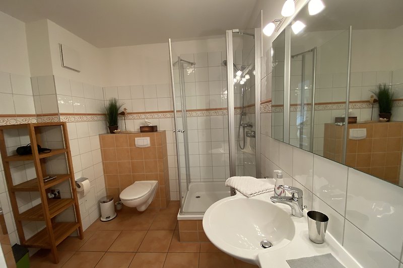 Badezimmer mit modernen Armaturen und Glasdusche.