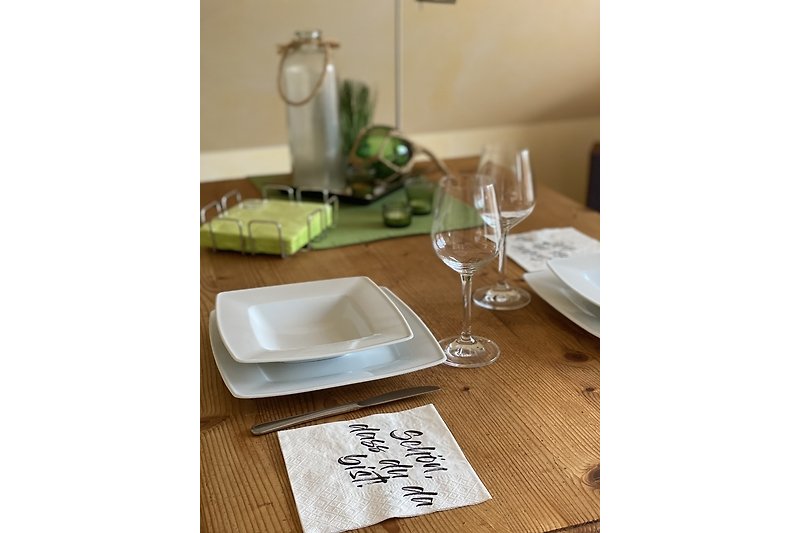Elegante Tischdekoration mit Porzellan, Besteck und Gläsern.