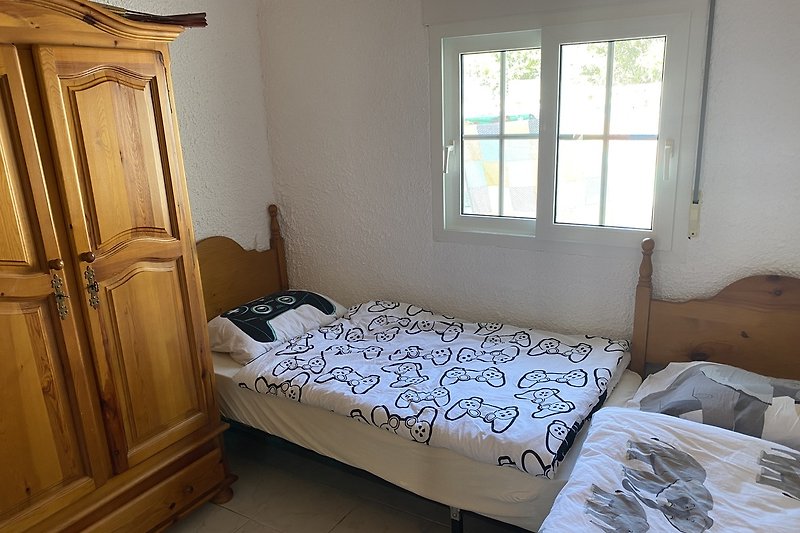 Schlafzimmer 2 mit Klimaanlage, Mückennetz am Fenster, Etagenbett, 2 Einzelbetten und Kleiderschrank