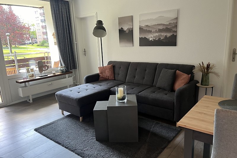 Modernes Wohnzimmer mit bequemer Couch, welche sich zum Schlafsofa ausziehen lässt.