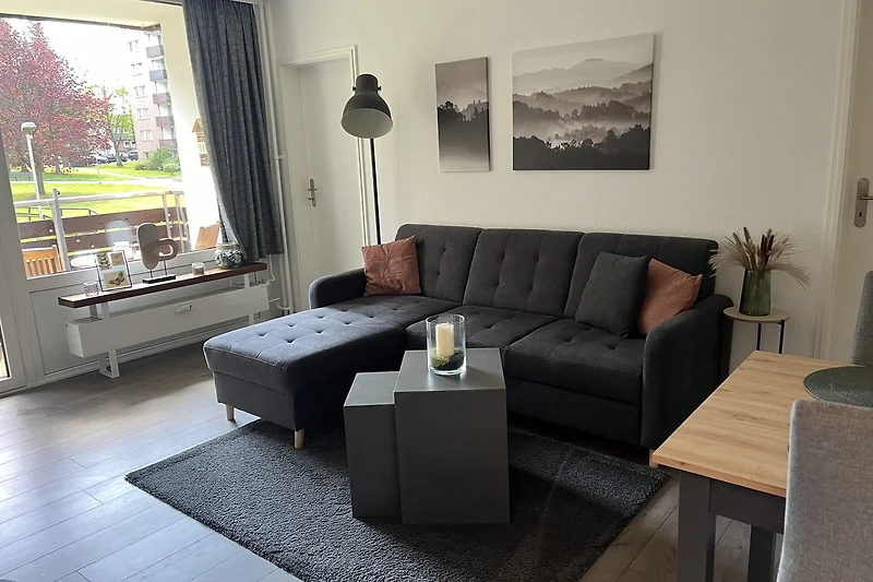 Modernes Wohnzimmer mit bequemer Couch, welche sich zum Schlafsofa ausziehen lässt.