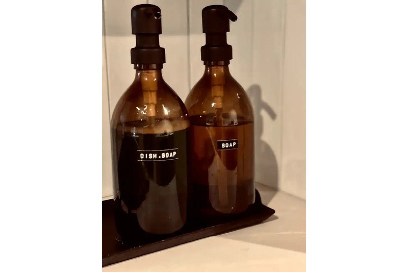Flüssige Getränke in Glasflaschen mit Korken und Etiketten.
