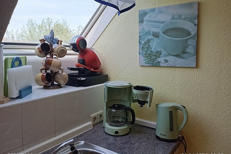 Küche mit Geschirr, Tassen, Kaffeemaschine und Porzellan.
