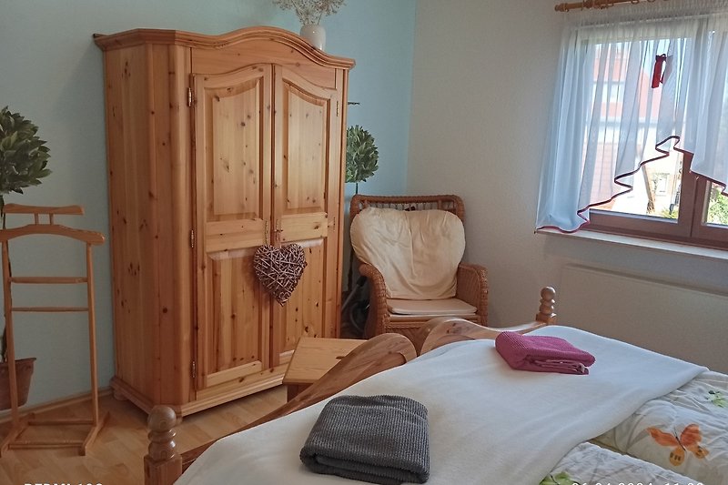 Gemütliches Schlafzimmer 1 mit Holzmöbeln und Pflanze.