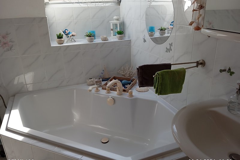 Modernes Badezimmer mit Badewanne, Waschbecken und Fliesen.