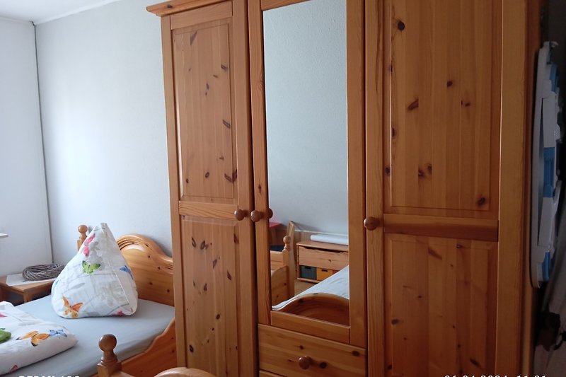 Schlafzimmer 2 mit Holzmöbeln, Bett und Fenster.