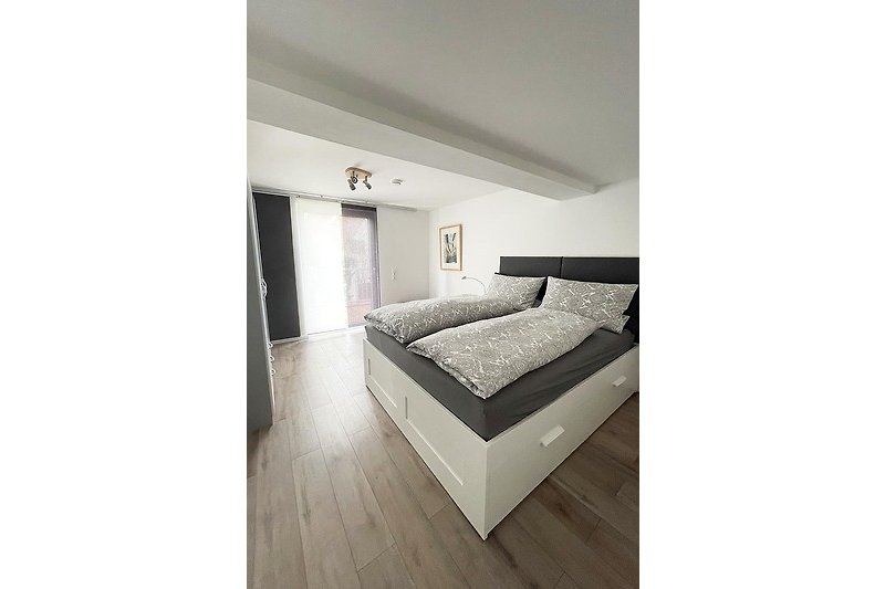 Schlafzimmer mit bequemem Bett (1,60 x 2,00 m) und Nachttisch-Leselampen.