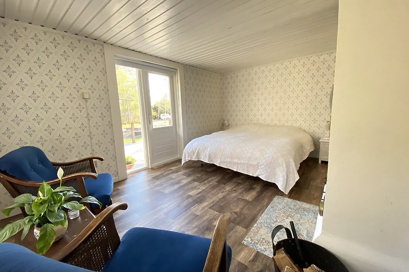 Modernes Schlafzimmer mit stilvollem Bett, Fenster und Pflanze.