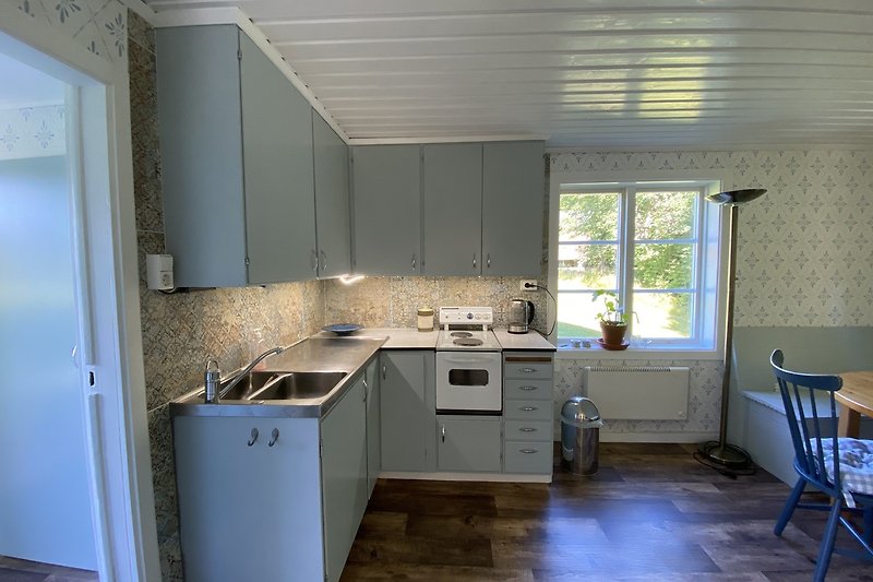 Moderne Küche mit Holzschränken, Fenster und Spüle.