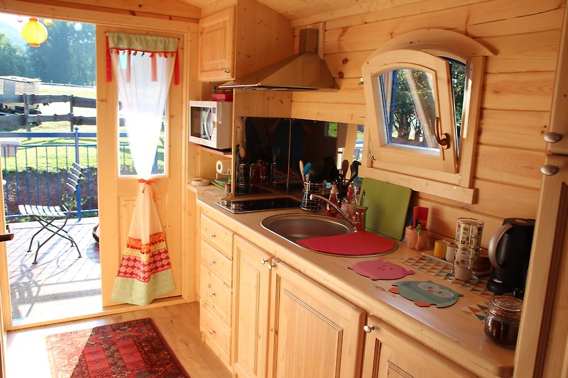 Küche mit Holzschränken, Spüle und Armatur.