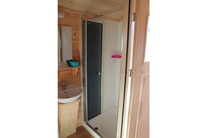 Bad mit Holzverkleidung, Fenster und Badewanne.