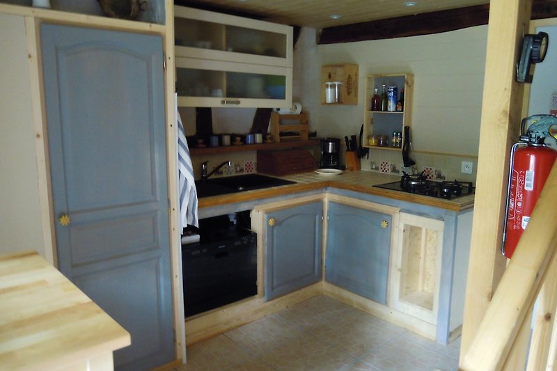 Moderne Küche mit Holzschränken, Arbeitsplatte und Geräten.