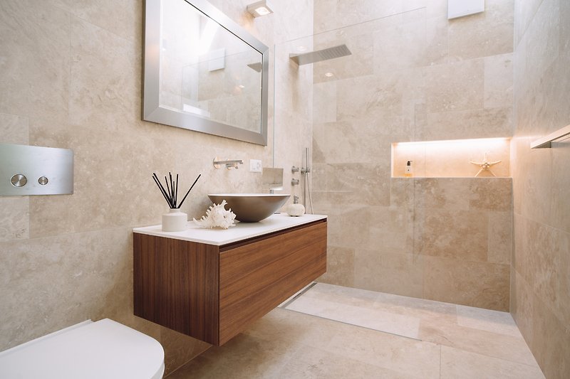 Elegantes Badezimmer mit modernem Waschbecken und Spiegel.