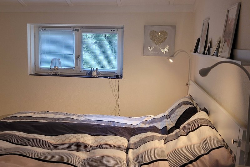Schlafzimmer mit gemütlichem Bett und Holzinterieur.