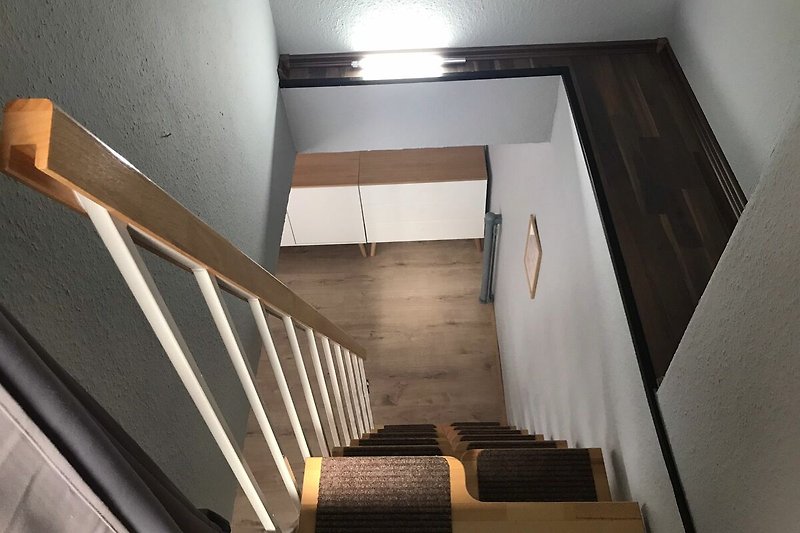 Steile Treppe vom Dachgeschoss ins Wohnzimmer