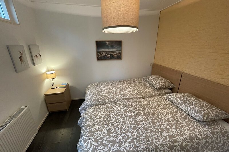 Stilvolles Schlafzimmer mit elegantem Holzbett und Lampen.