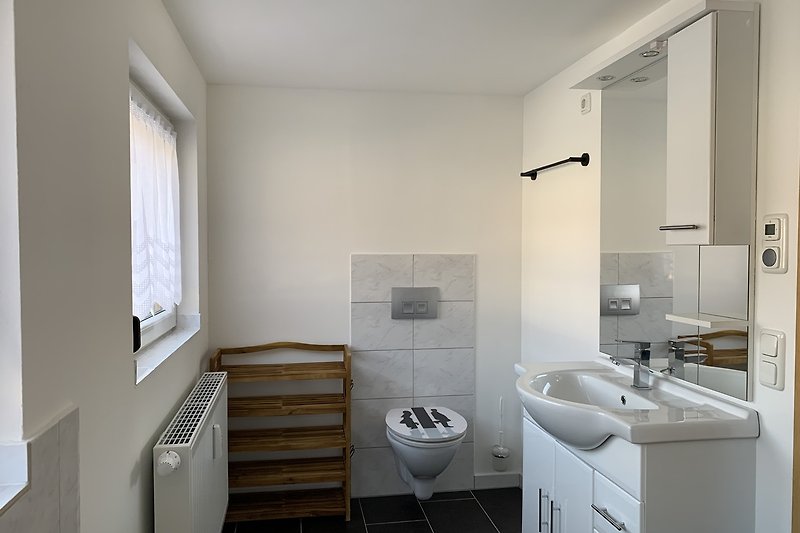 Modernes Badezimmer mit Spiegel, Waschbecken, Dusche und Badewanne.