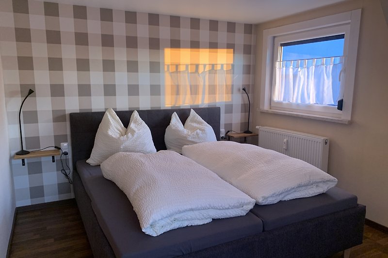 Stilvolles Schlafzimmer mit gemütlichem Bett und Lampen.