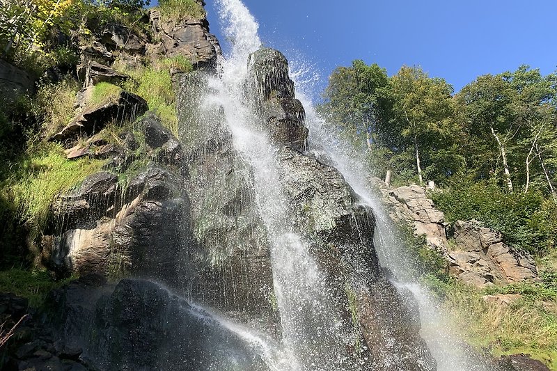 Wasserfall im tropischen Regenwald mit Fluss und Felsen.