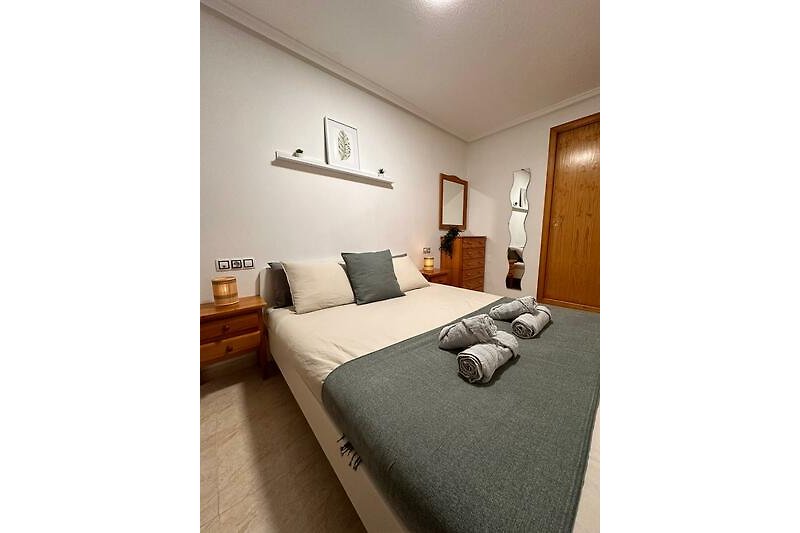 Schlafzimmer mit elegantem Bett und stilvoller Beleuchtung.