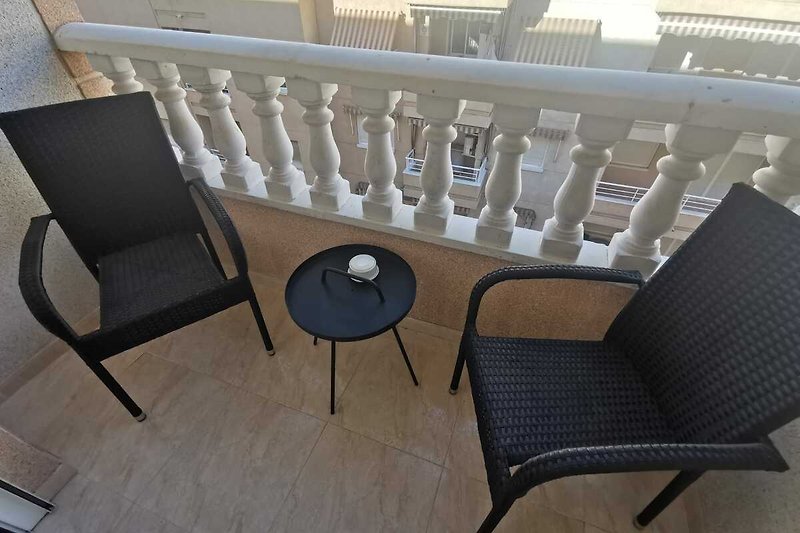 Knus balkon met 2 stevige stoelen en bijzettafeltje.