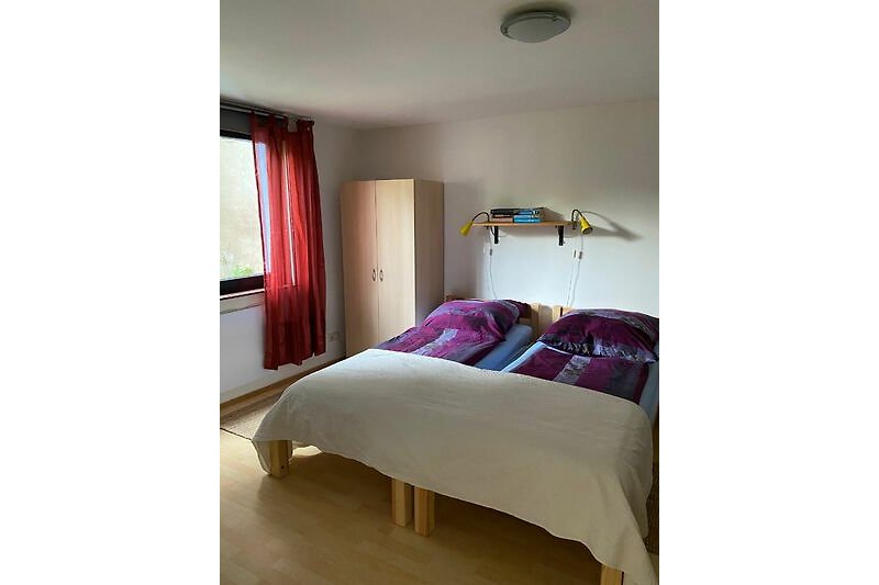 Stilvolles Schlafzimmer mit Holzbett, Bettwäsche und Lampen.