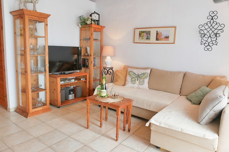 Wohnzimmer mit Holzmöbeln, Couch, Tisch und Lampe.