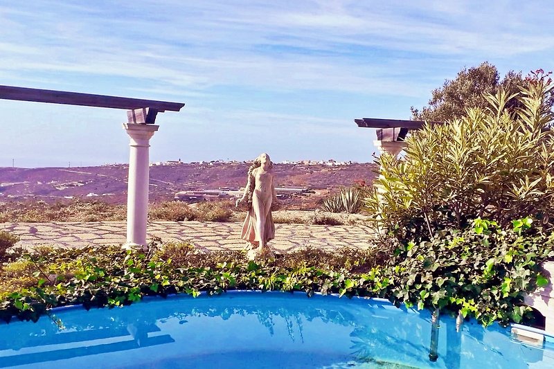 runder, kleiner Pool mit Skulptur eines Mädchens und Blick auf den Horizont - perfekt für Entspannung!