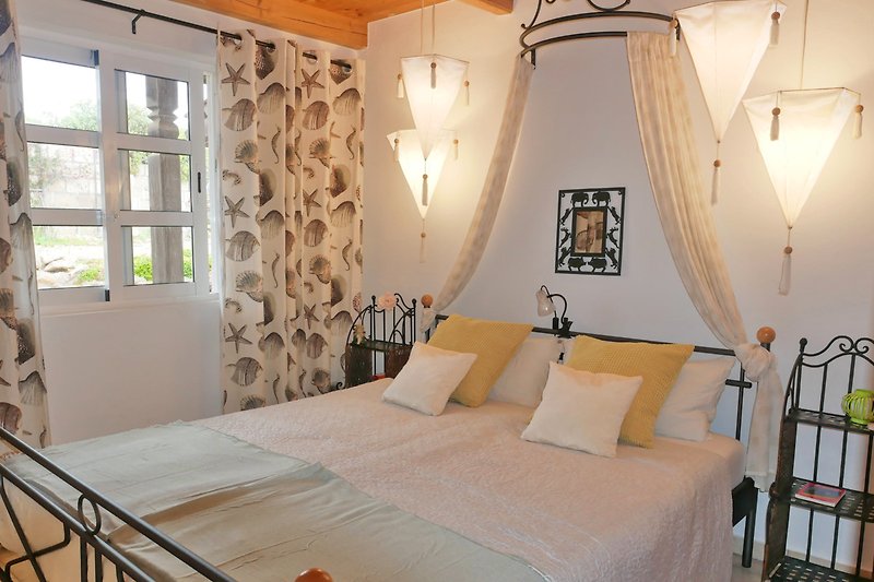 Schlafzimmer mit gemütlichem Bett, stilvoller Beleuchtung und elegantem Dekor.