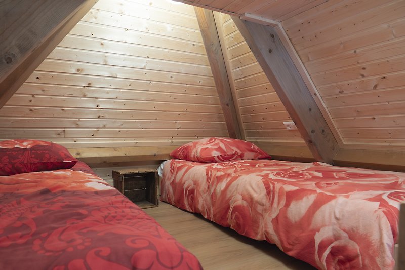 Schlafzimmer mit Holzbett und Fenster.